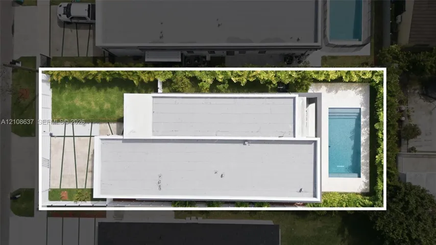Aerial perspective of property exterior featuring a swimming pool, concrete hardscaping with grass inlays, and perimeter privacy hedging