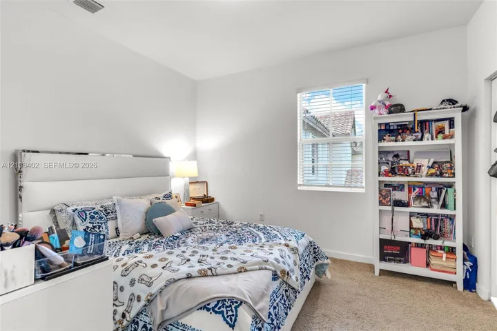 Neutral interior space featuring high ceilings, wall-to-wall carpeting, and a single-hung window with horizontal blinds