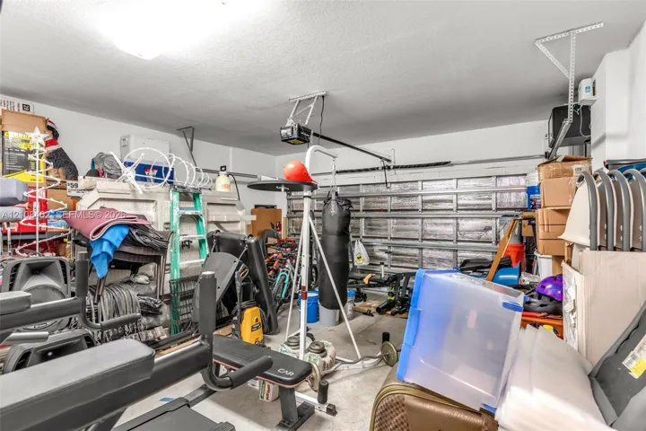 Garage space featuring a metal sectional overhead door and an installed motorized door opener