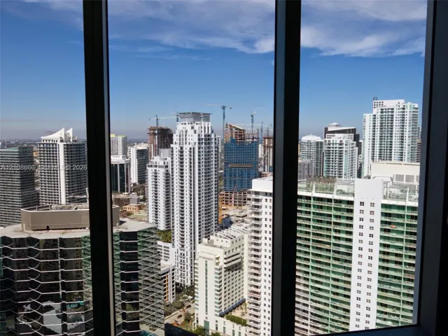 Floor-to-ceiling windows with dark-finish mullions framing an expansive cityscape