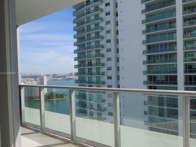 Private balcony with a glass and metal railing, concrete flooring, and water scenery