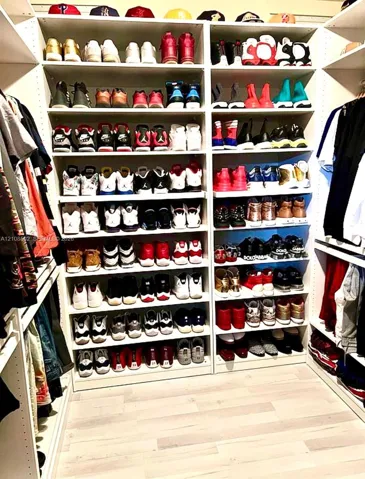 Custom floor-to-ceiling shelving system with adjustable tiers and light-toned wood-finish flooring