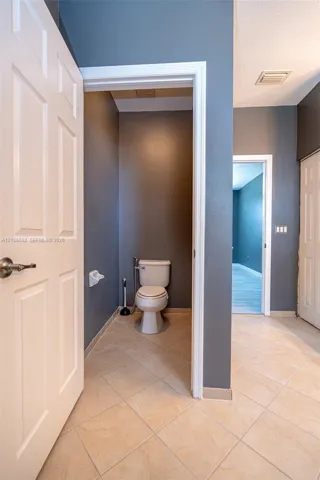 Ceramic tile flooring, white six-panel interior doors, and solid-surface walls
