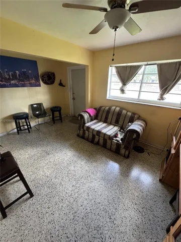 Terrazzo flooring, multi-pane window, and ceiling fan with integrated lighting