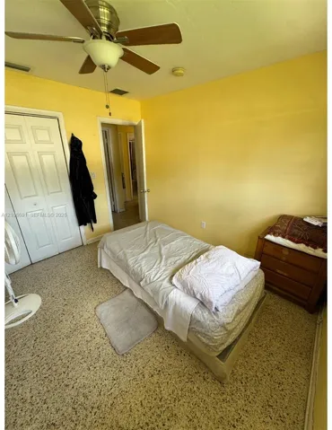 Interior space featuring terrazzo flooring, ceiling-mounted fan with integrated lighting, and dual-panel closet doors