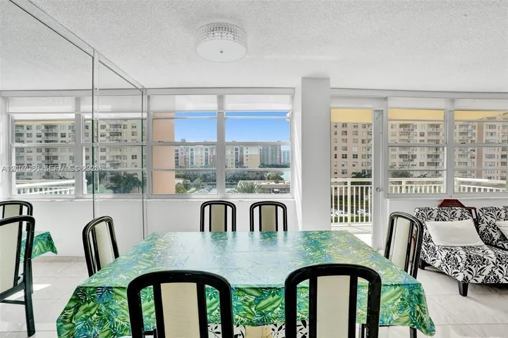 Expansive wall of windows featuring horizontal casement panes, neutral tile flooring, flush-mount tiered ceiling lighting, and a glass-enclosed wall​​‌​​​​‌​​‌‌​‌‌​​​‌‌​‌​‌​‌​​​‌​​ partition