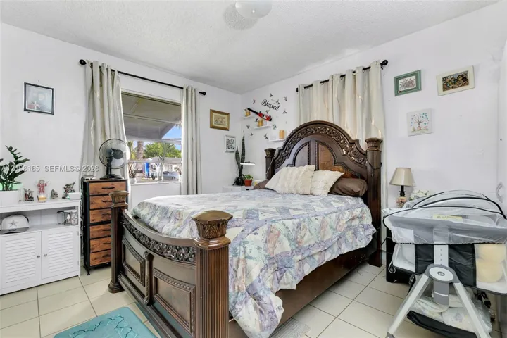 Room with ceramic tile flooring, dual windows with wall-mounted curtain rods, and a ceiling-mounted light fixture