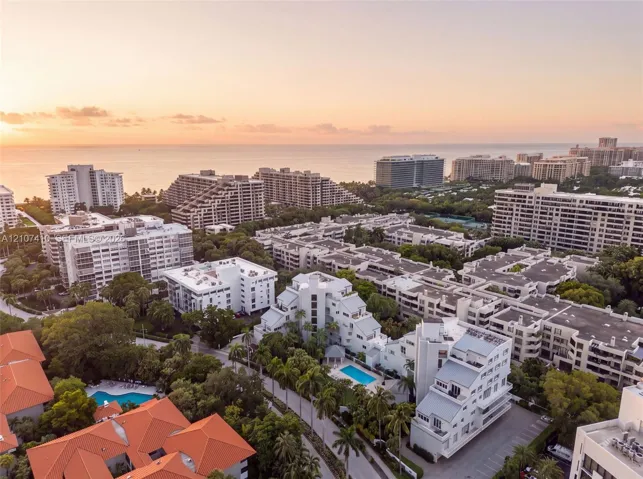 Aerial perspective showcasing dense tropical landscaping, multiple swimming pools, and proximity to the coastline