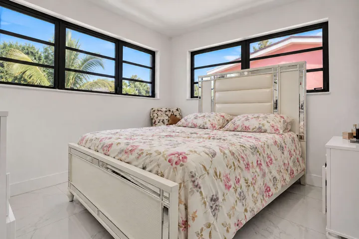 Bright interior space featuring light-toned tile flooring, neutral walls, and large horizontal windows with black frames