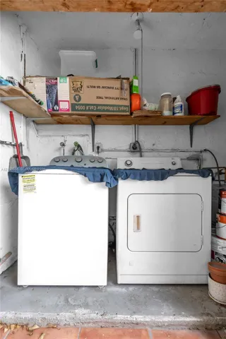 Laundry area featuring wall-mounted wooden shelving and concrete flooring