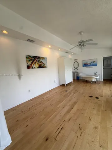 Wood-finish flooring, recessed ceiling lighting, clawfoot soaking tub, pedestal sink, and ceiling fan