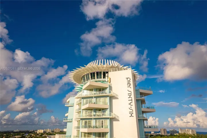 High-rise exterior featuring multi-level wraparound balconies, expansive glass sliding doors, and a distinct crown architectural detail