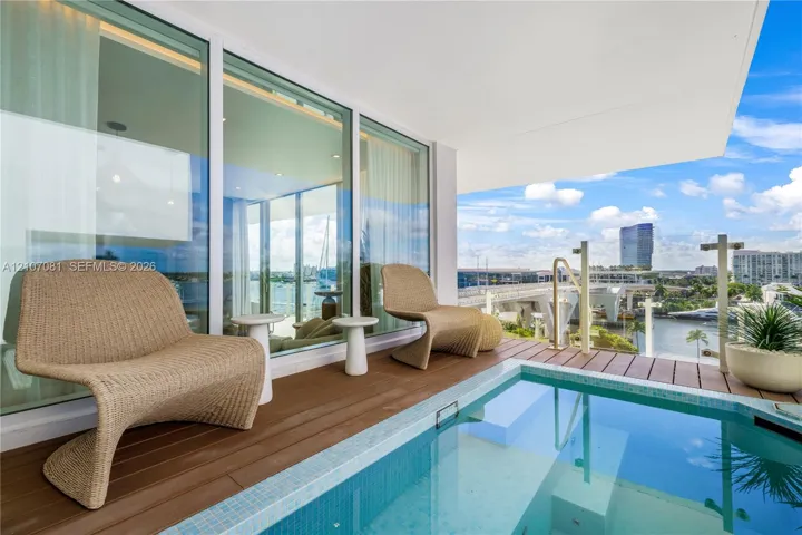 Covered balcony featuring wood-finish decking, a built-in plunge pool with tiled lining, floor-to-ceiling glass panel walls, and a glass-paneled railing