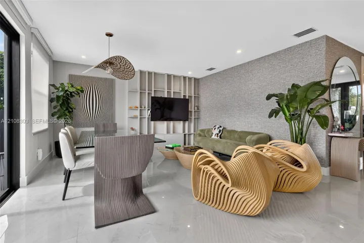 Open-concept living space featuring high-gloss tile flooring, custom floor-to-ceiling built-in shelving, textured wall treatment, and recessed lighting