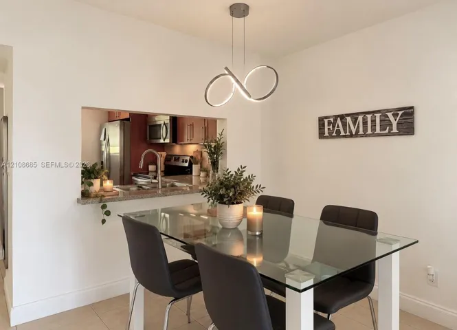 Modern LED pendant light fixture, pass-through kitchen opening, and neutral tile flooring