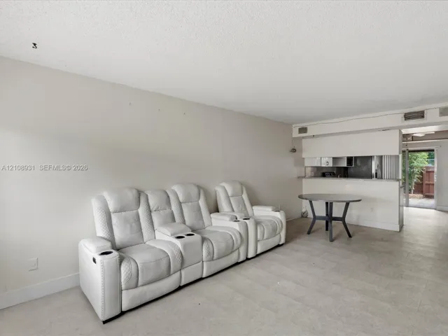 Neutral-toned interior featuring tiled flooring and a kitchen pass-through counter