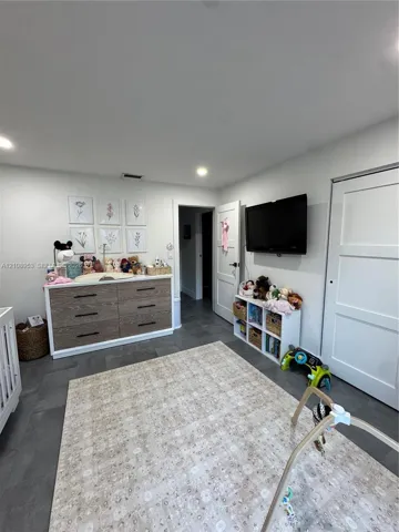 Neutral-toned interior featuring recessed lighting, large-format grey tile flooring, and solid-core paneled doors