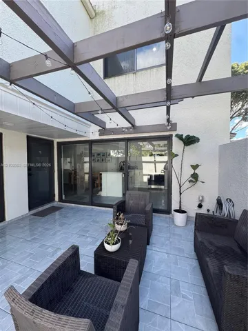 Outdoor patio featuring tile flooring, a pergola, and large multi-panel sliding glass doors