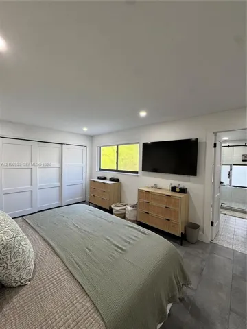 Recessed ceiling lighting, large-format tile flooring, oversized sliding closet doors, and a horizontal window