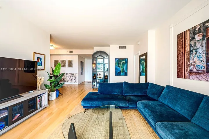 Living area featuring wood-finish flooring and a built-in arched display cabinet