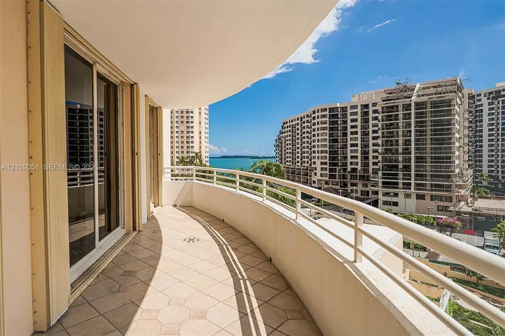 Curved balcony featuring tile flooring and metal railings