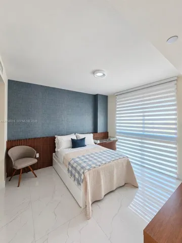 Polished stone-look flooring, custom vertical wood-slat wall paneling, textured dark-toned accent wall, and horizontal dual-layer window treatments