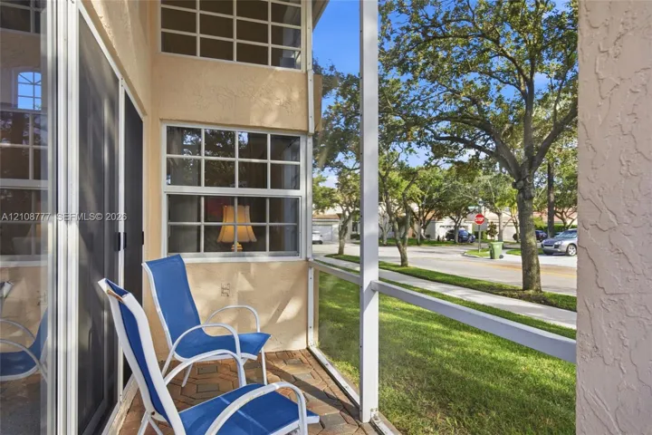 Screened-in patio featuring paver flooring, multi-light windows, and exterior stucco finish
