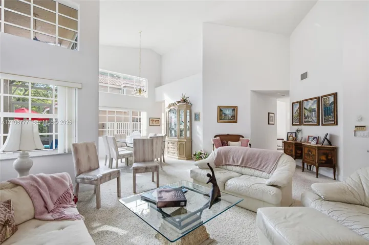 Vaulted ceilings, expansive multi-pane windows, and a suspended dining area light fixture