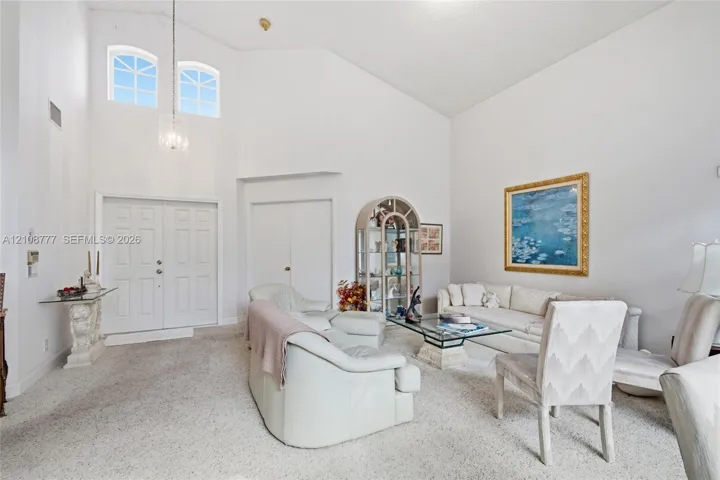 High ceilings featuring a multi-light pendant fixture, double entry doors, and arched transom windows