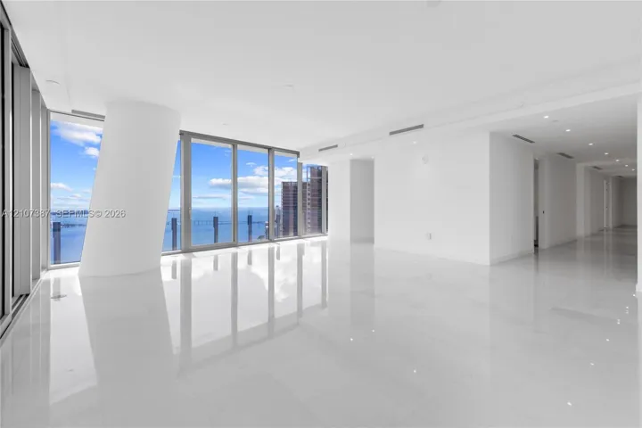 Open-concept interior featuring floor-to-ceiling glass windows, water and skyline scenery, polished tile flooring, and recessed ceiling lighting