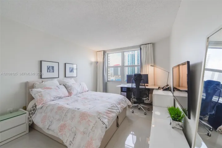 Bright room featuring large windows, high-gloss tile flooring, and neutral wall tones