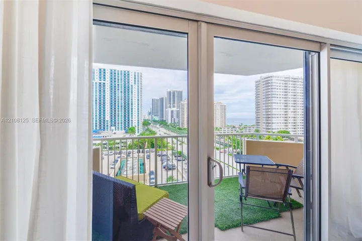 Floor-to-ceiling sliding glass door opening to a private balcony with metal railings