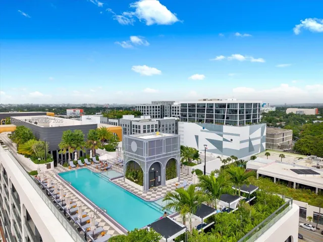 Rooftop amenity deck featuring a rectangular swimming pool, landscaped gardens, paved patio area, and architectural pavilion structure