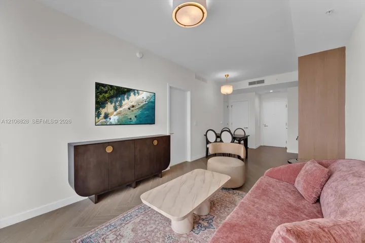 Herringbone-patterned wood-finish flooring, recessed lighting, and integrated wood-panel accent wall