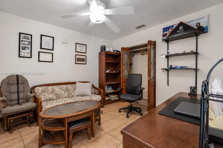 Tile flooring, ceiling fan with integrated lighting, and bi-fold closet doors featuring decorative glass inserts