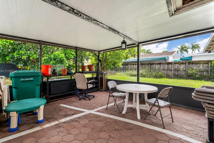 Screened-in patio featuring paver flooring, a solid panel roof, and metal framing