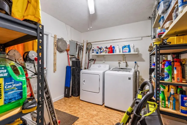 Utility room featuring white top-loading laundry appliances and wall-mounted shelving