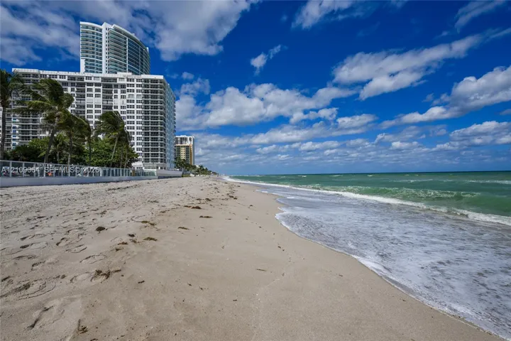 Direct oceanfront access with sandy beach frontage and perimeter security fencing