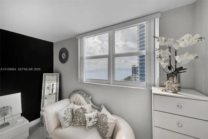 Dual-pane window with vertical blinds, crisp grey wall paint, and bold black accent wall
