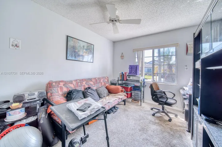 Room featuring a ceiling fan, wall-to-wall carpeting, and a multi-pane window