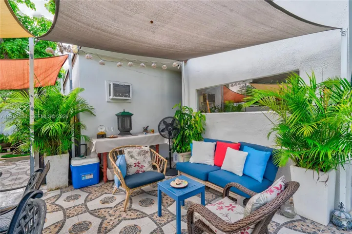 Outdoor patio featuring patterned stone tile flooring and a structural fabric shade canopy