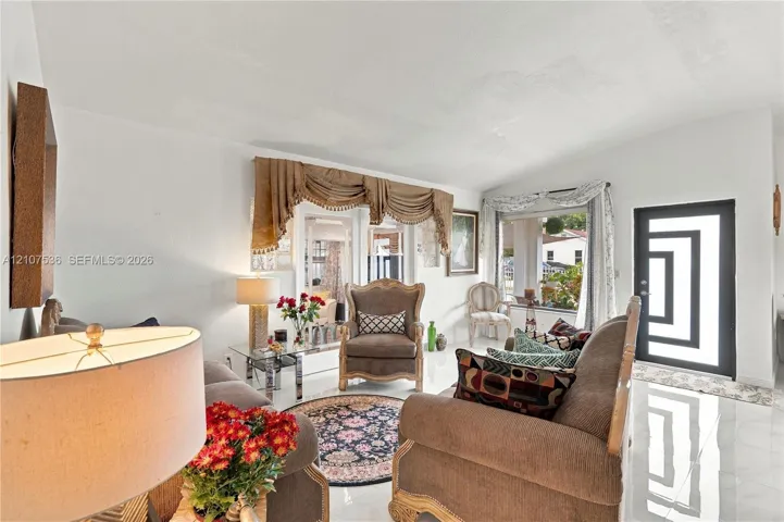 Vaulted ceilings, light-reflective tile flooring, and a modern front door with geometric glass panels