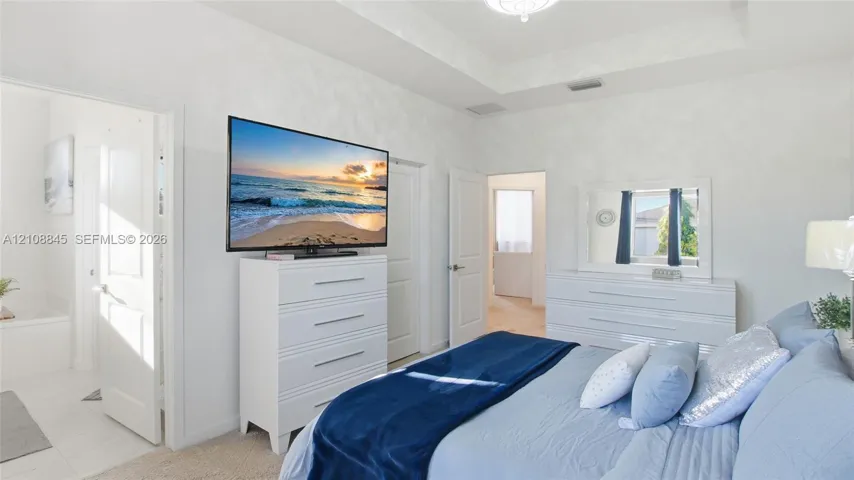 Tray ceiling with recessed lighting and neutral wall finishes