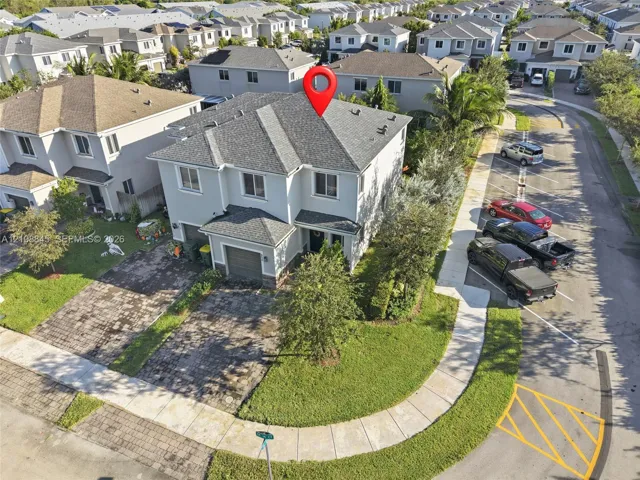 Two-story residence featuring a shingled roof, stucco exterior, paver driveway, single-car garage, and corner lot landscaping