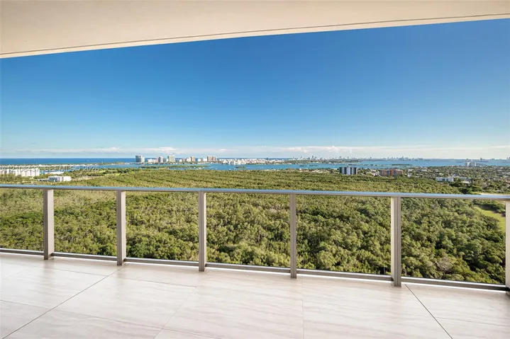 Covered balcony featuring large-format stone-finish tile flooring and a minimalist metal railing