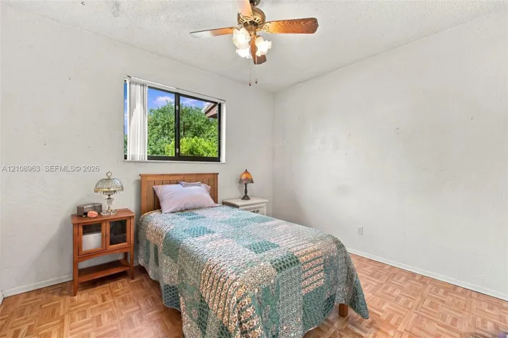 Parquet flooring, single-pane window, and ceiling-mounted light fixture with fan