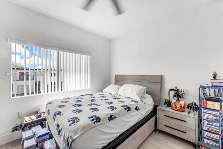 Neutral-toned room featuring a ceiling fan and vertical window blinds