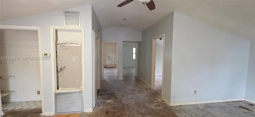Vaulted ceiling featuring a central ceiling fan
