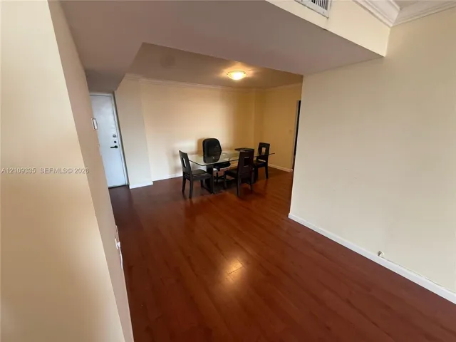 Open interior space featuring wood-finish flooring and crown molding