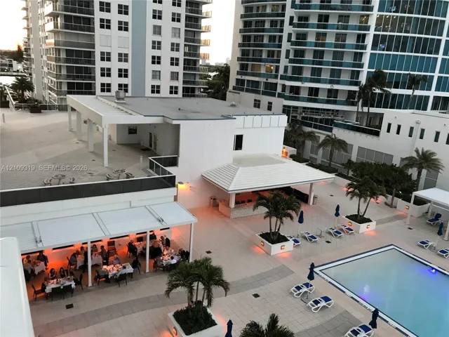 Outdoor terrace featuring a swimming pool, multiple covered dining pavilions, built-in bar area, and tiled hardscaping with integrated landscaping
